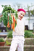 Girl on allotment with carrots