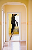Man changing a light-bulb on a ladder