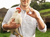 Bauer hält Ei und Henne
