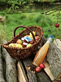 Äpfel im Korb mit Marmeladenglas und Saft