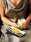 A woman with a cocktail and savoury muffins
