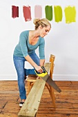 Woman sawing plank