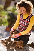 Junge Frau bei der Gartenarbeit im herbstlichen Garten