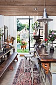 Dining table with long wooden bench and classic bentwood bar stools at counter