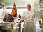 Baker holding whisk in cake shop
