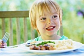 Smiling boy eating plate of food