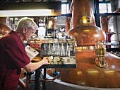 Worker checking whisky in distillery