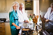 Älteres Ehepaar in Bademänteln beim Kochen