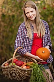 Woman gathering vegetables in garden