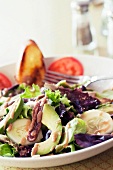 Serving of Salad with Anchovies, Avocado, Cucumbers and Mixed Greens