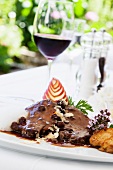 Rhenish Sauerbraten (marinated pot roast) with raisins and napkin dumplings and a glass of red wine