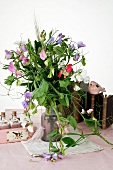 Vase of sweet peas in front of books