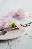 Table place setting - cutlery and Bell Flowers wrapped with a colorful ribbon
