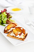 Rye bread topped with raw milk goat's cheese and plums