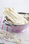 Peeled white asparagus in a colander