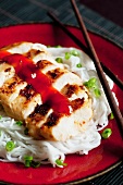 Chicken breast with a sweet chilli sauce on rice noodles