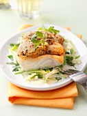 Cod fillet with a herb and nut crust on a leek medley