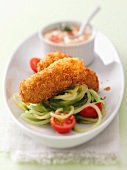 Potato croquette on a bed of vegetable spaghetti with a dip