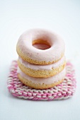 Doughnuts with pink sugar icing on a crocheted coaster