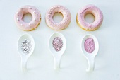 Doughnuts with pink sugar icing, sugar sprinkles and sugar pearls