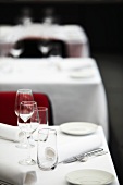Three tables in a restaurant laid with white cloths