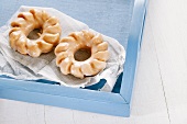 Two iced doughnuts on a blue tray
