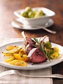 Saddle of lamb with Brussels sprouts and potato wedges