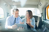 Pair talking business with a tablet computer in a car