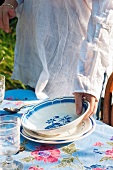 A woman place a plate on a garden table