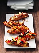 Crostini topped with chanterelle mushrooms, tomatoes and olives