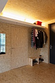 Open-plan cloakroom in foyer clad in chipboard with indirect lighting