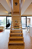 Modern, wooden staircase in open-plan interior