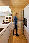 weiße Designerküche mit Mittelblock in spanplattenverkleidetem Raum