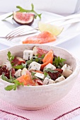 Salat mit Rucola, Lachs, Feigen, getrockneten Tomaten und Blauschimmelkäse