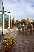 Delicate garden furniture on large roof terrace with wooden flooring