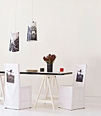 Dining table on trestles, chairs with printed loose covers and lampshades with similar designs