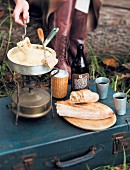 An autumn picnic with cheese fondue on a camping stove