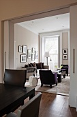 Blick vom Esszimmer durch Schiebetüren ins Wohnzimmer mit weißem Beistelltisch lila Sessel