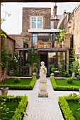 Symmetrische gestalteter Innenhof mit Statue, Buchsbaumhecke und gepflastertem Weg