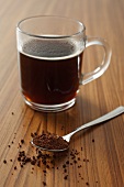 A cup of instant coffee and a spoonful of instant coffee powder