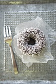 A doughnut with chocolate glaze and grated coconut