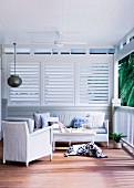 Cozy veranda with ceiling fan and sleeping dog in front of white wooden railing