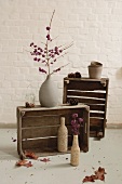 Two wooden boxes with Fall decorations in front of a white washed wall