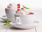 Strawberry ice cream topped with meringue in cappuccino cups