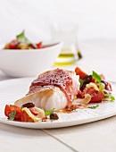 Cod wrapped in ham with a tomato and olive salad
