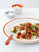 Pasta with a minced meat sauce, mozzarella and basil