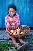 Lachendes Mädchen einen Apfel betrachtend