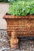 Antique flower trough on metal feet with a small bust of woman as decoration