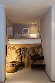 In den Berg gebautes, minimalistisches Schlafzimmer mit Metallbalken als Stufen