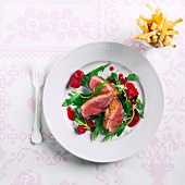 Duck breast with rocket and a raspberry vinaigrette and chips